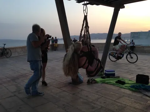 Blonde Hangs Suspended in Rope Bondage Outdoors Fully Clothed – photo 14 of 16