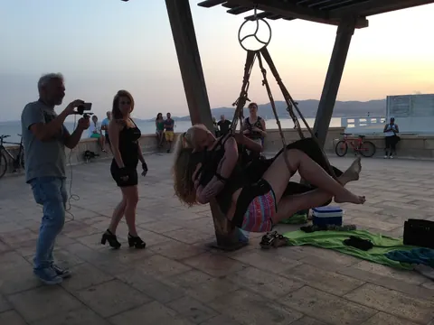 Blonde Hangs Suspended in Rope Bondage Outdoors Fully Clothed – photo 4 of 16