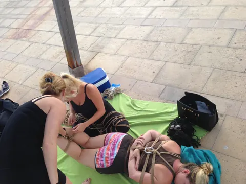 Blonde Hangs Suspended in Rope Bondage Outdoors Fully Clothed – photo 9 of 16