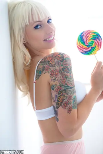 Busty Blonde in Lingerie Poses with Lollipop and Spreads