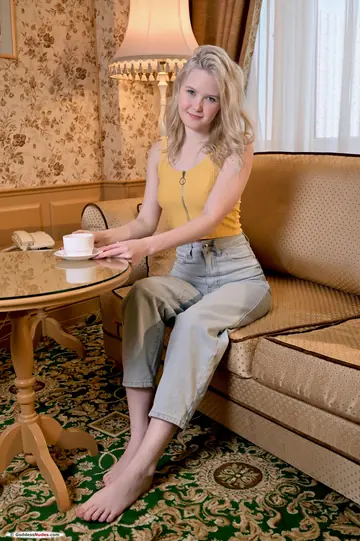 Slim Blonde Displays Her Shaved Pussy and Ass on the Sofa