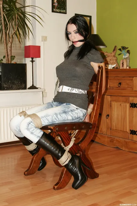 Brunette in Jeans and Heels Tests Restraints While Tied to a Chair – photo 1 of 20