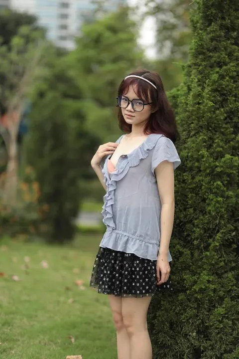Brunette in Glasses and Skirt Poses Outdoors Fully Clothed – photo 18 of 21
