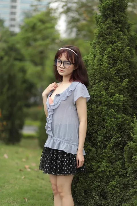 Brunette in Glasses and Skirt Poses Outdoors Fully Clothed – photo 17 of 21