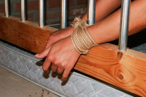 Busty Sub Ball-Gagged and Cuffed to a Cage – photo 11 of 17