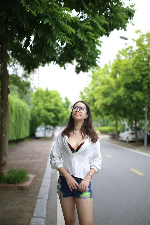 Asian Brunette Poses in Shorts and Glasses Outdoors – photo 10 of 21