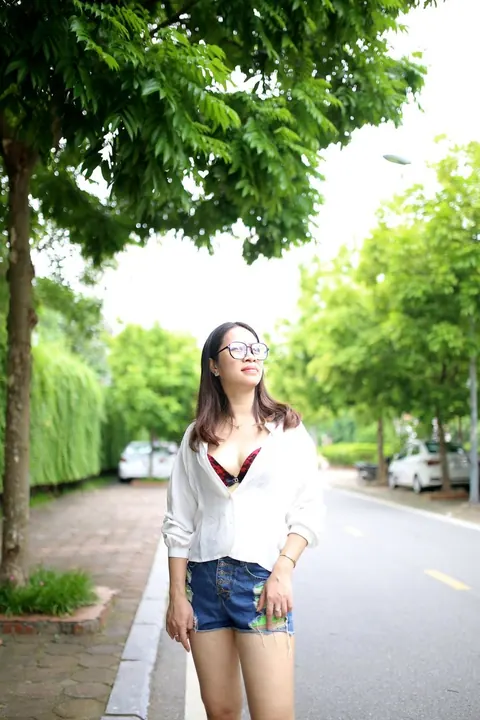 Asian Brunette Poses in Shorts and Glasses Outdoors – photo 11 of 21