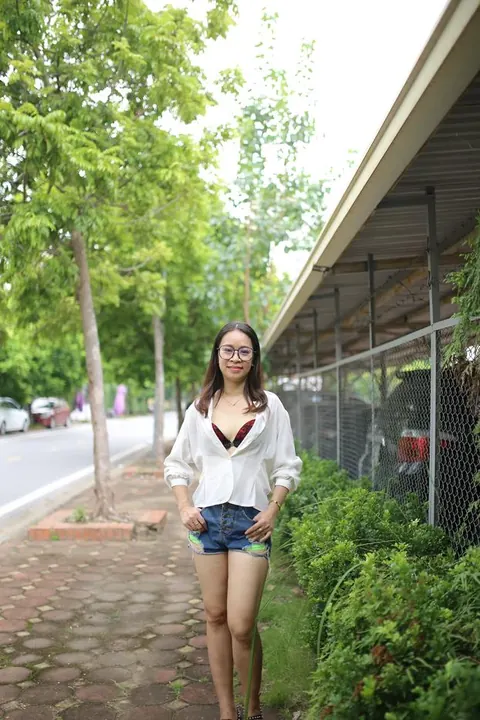Asian Brunette Poses in Shorts and Glasses Outdoors – photo 3 of 21