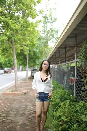 Asian Brunette Poses in Shorts and Glasses Outdoors