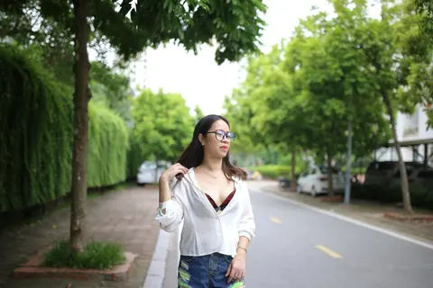 Asian Brunette Poses in Shorts and Glasses Outdoors – photo 9 of 21