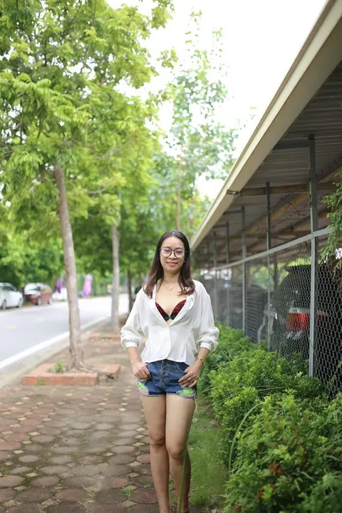 Asian Brunette Poses in Shorts and Glasses Outdoors – photo 4 of 21