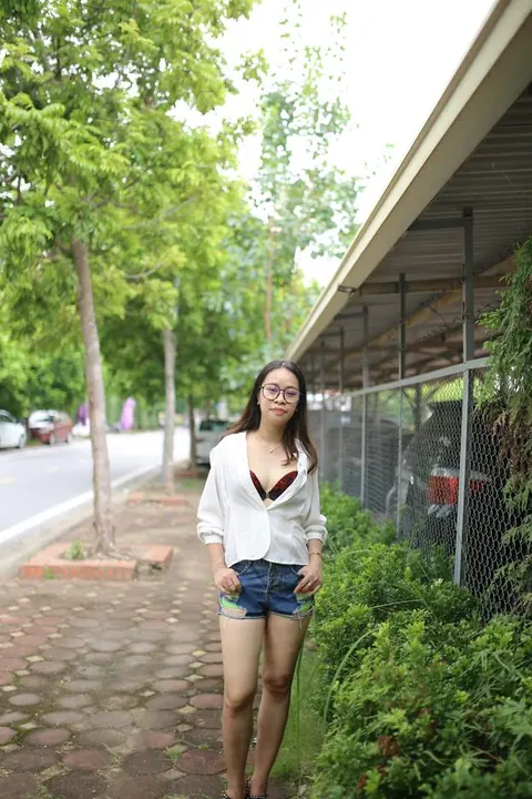 Asian Brunette Poses in Shorts and Glasses Outdoors – photo 20 of 21