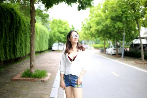 Asian Brunette Poses in Shorts and Glasses Outdoors – photo 12 of 21