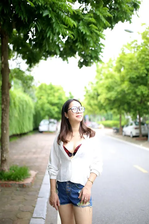 Asian Brunette Poses in Shorts and Glasses Outdoors – photo 13 of 21
