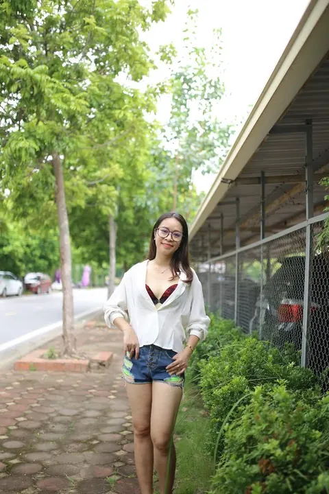 Asian Brunette Poses in Shorts and Glasses Outdoors – photo 2 of 21