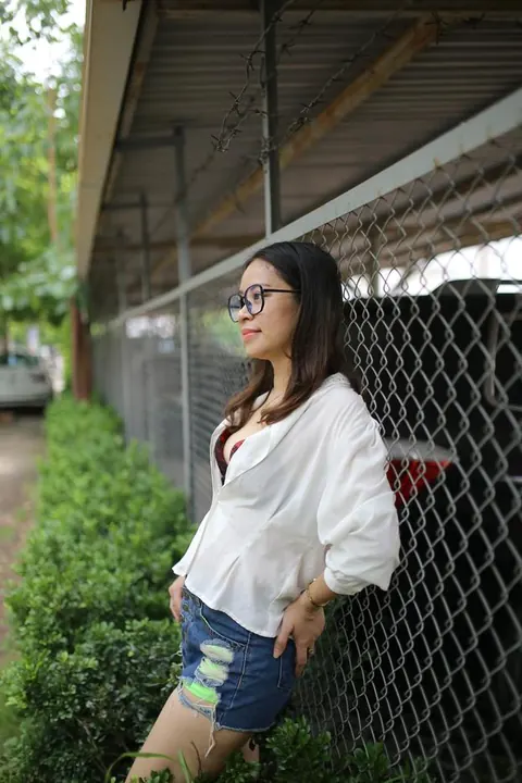 Asian Brunette Poses in Shorts and Glasses Outdoors – photo 5 of 21